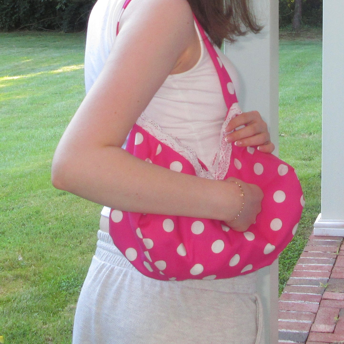 Person holding a pink polka dot bag outdoors