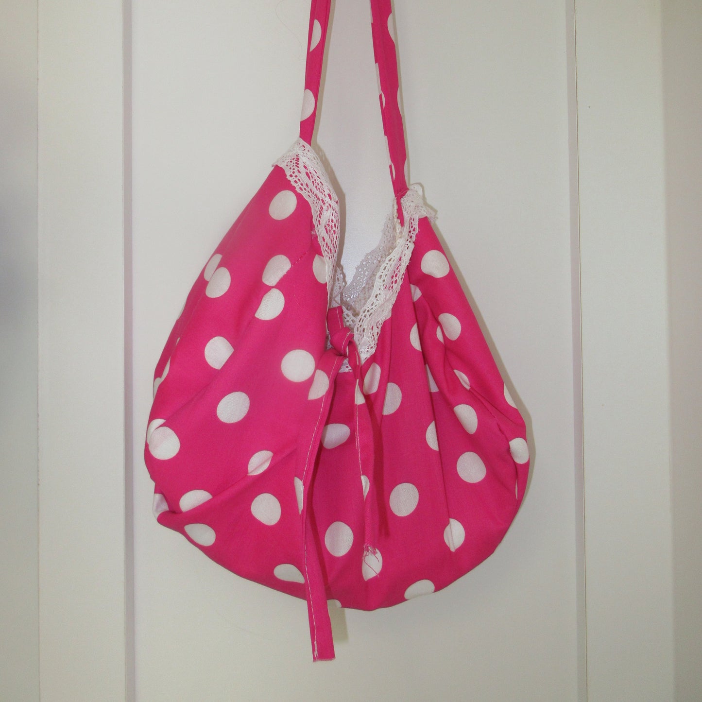 Pink bag with white polka dots on a white background
