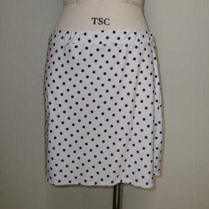 White skirt with black polka dots on a mannequin against a plain background