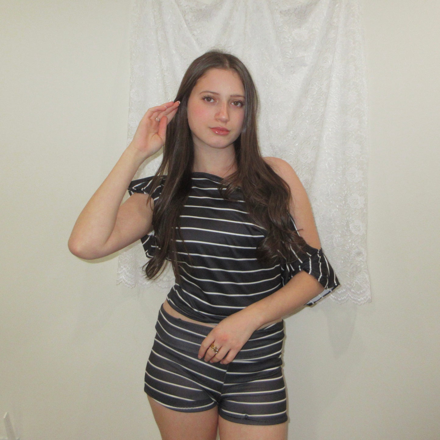 Woman wearing a black and white striped outfit against a plain background