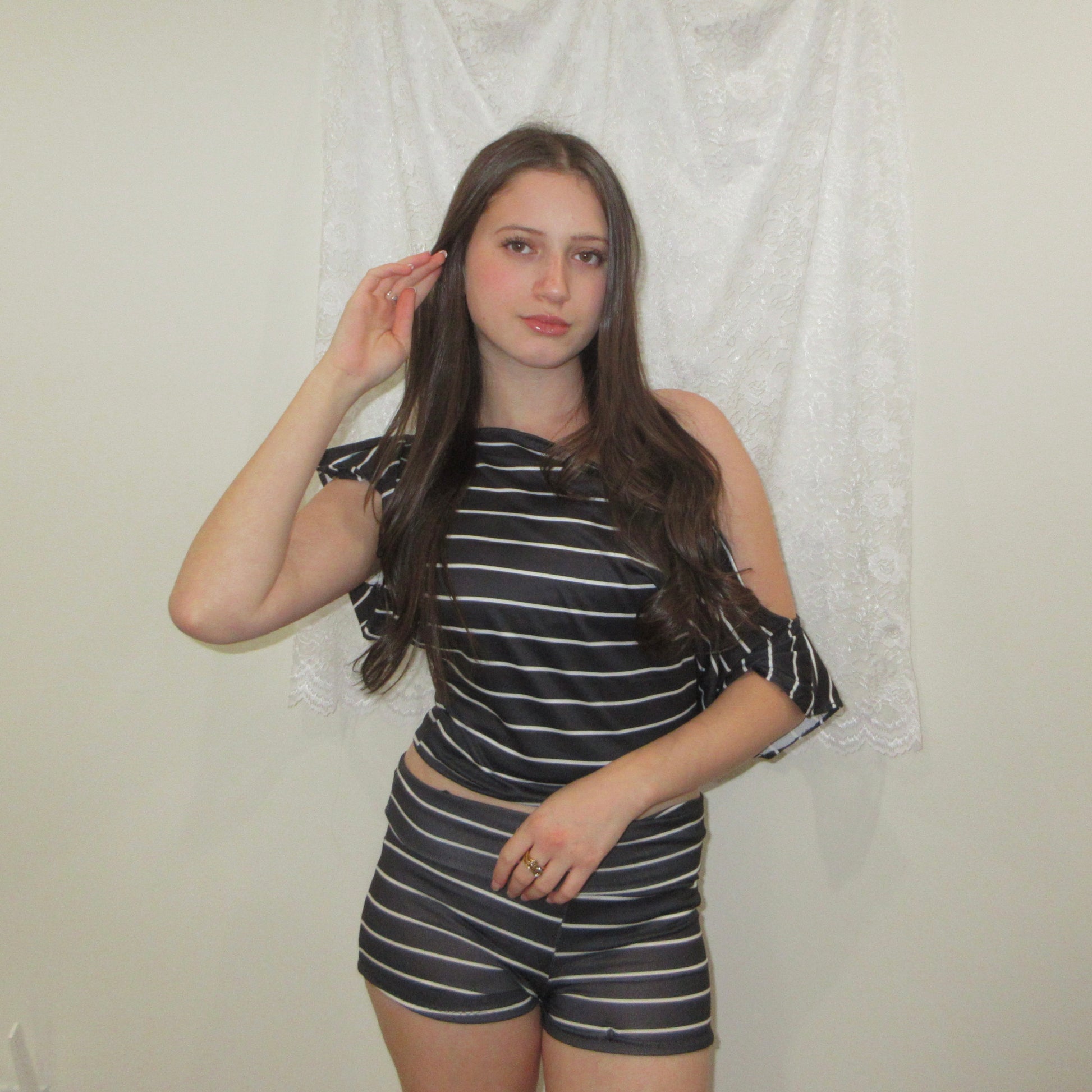 Woman wearing a black and white striped outfit against a plain background