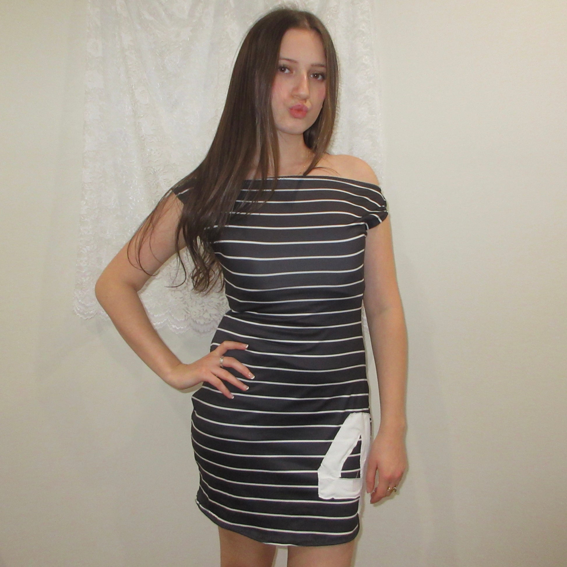 Woman wearing a black and white striped dress with a number '4' on a plain background