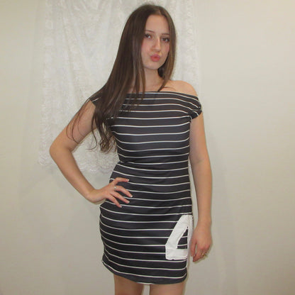 Woman wearing a black and white striped dress with a number '4' on a plain background