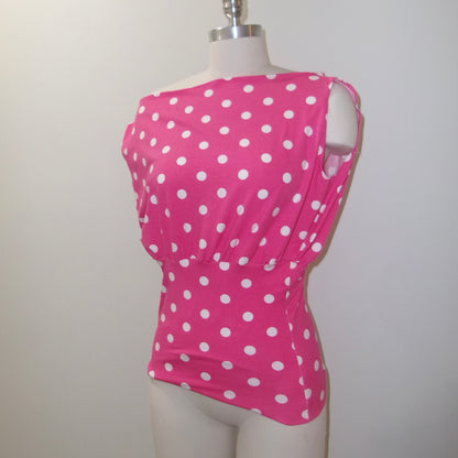 Pink polka dot top on a mannequin against a plain background