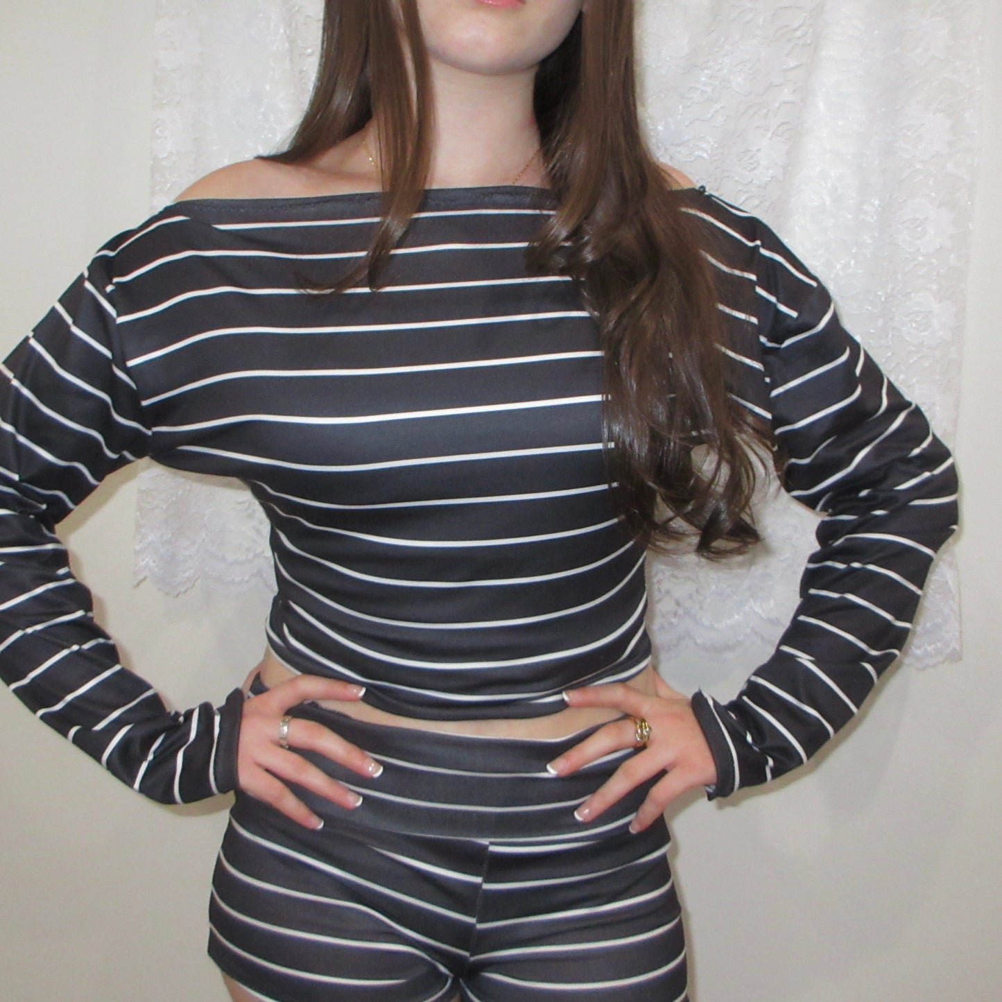 Person wearing a black and white striped outfit against a neutral background