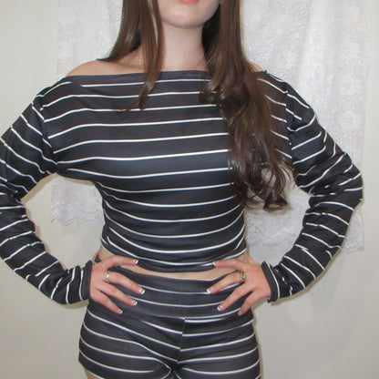 Person wearing a black and white striped outfit against a neutral background