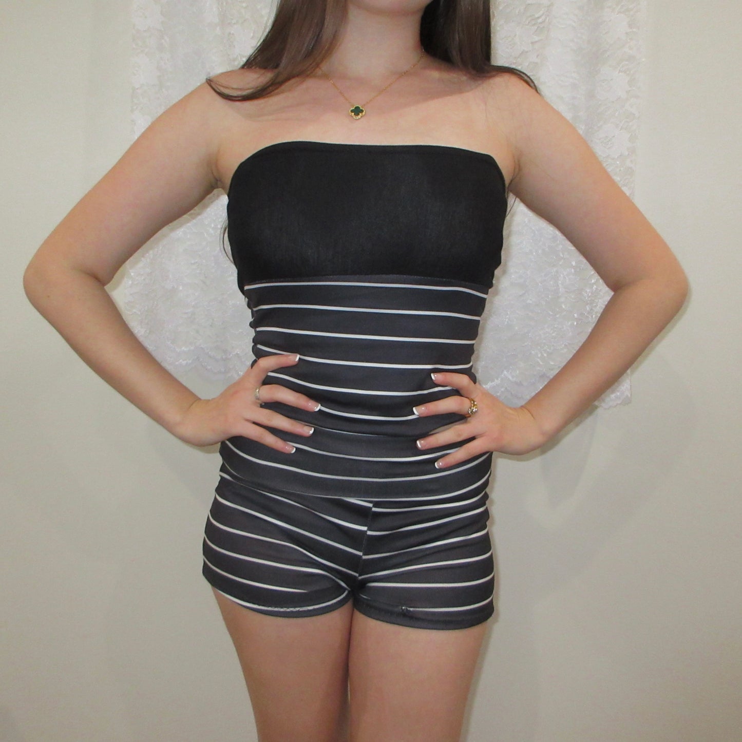 Person wearing a black and white striped outfit against a neutral background