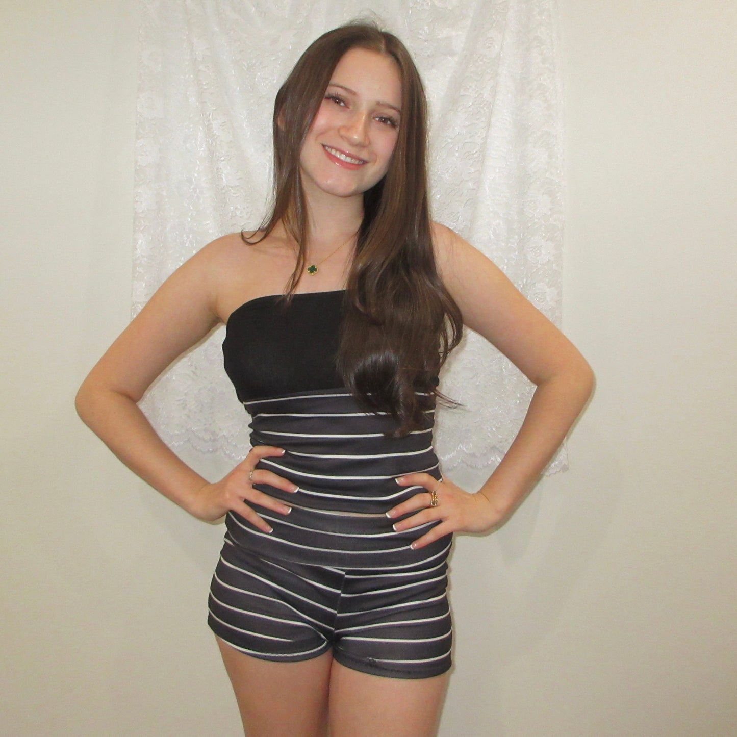 Woman wearing a black and white striped outfit against a plain background