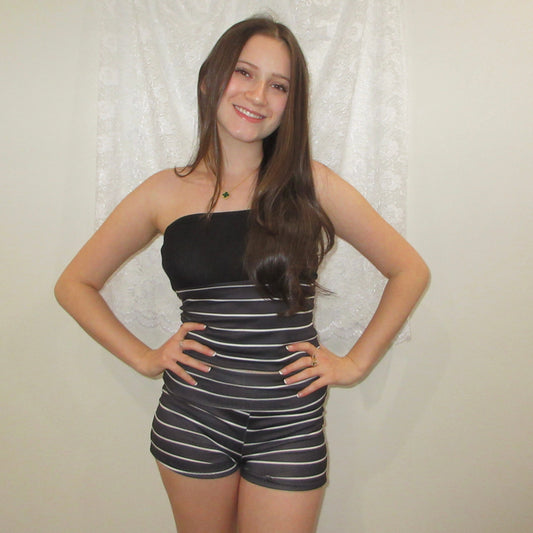 Woman wearing a black and white striped outfit against a plain background