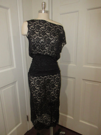Black lace dress on a mannequin against a white door background