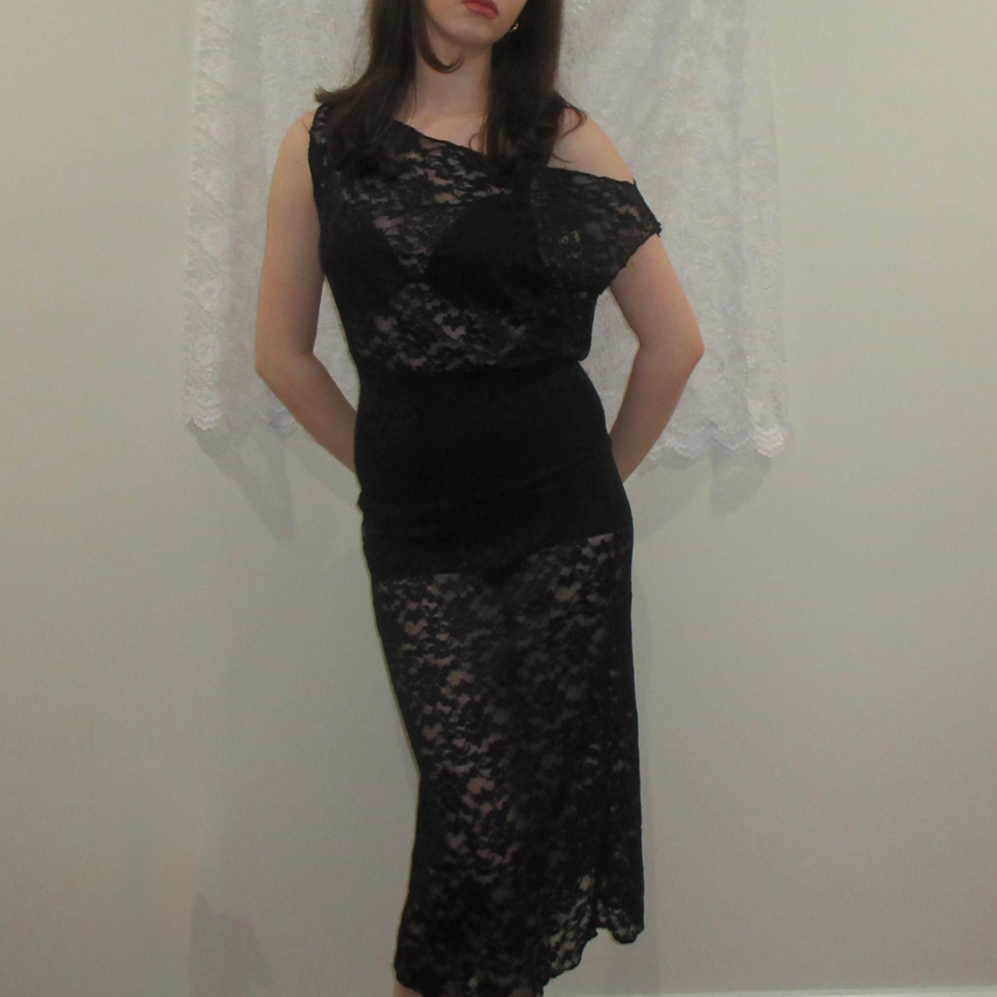 Black lace dress worn by a person against a neutral background