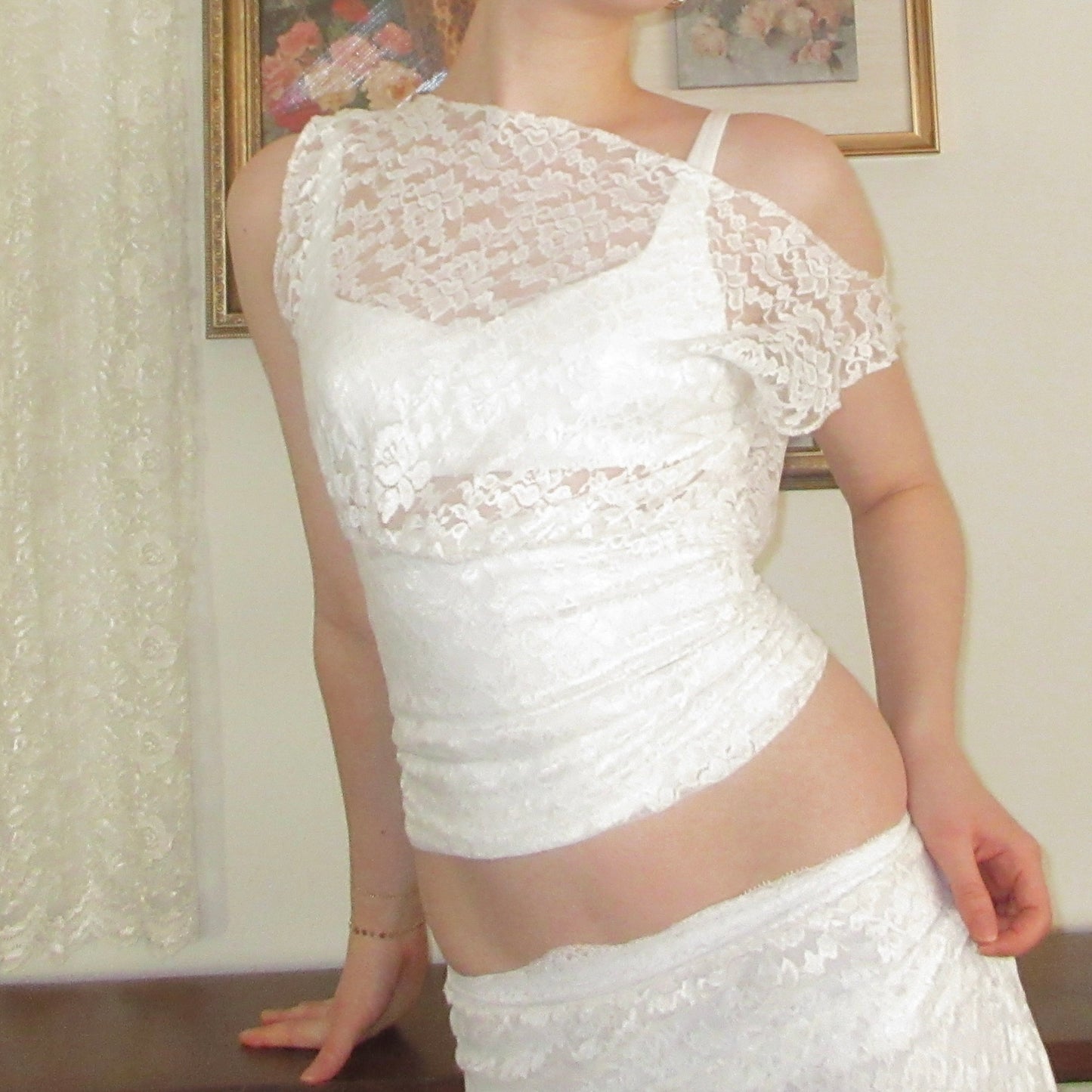 White lace dress worn by a person, with a neutral background