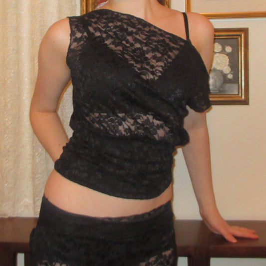 Person wearing a black lace top and skirt.