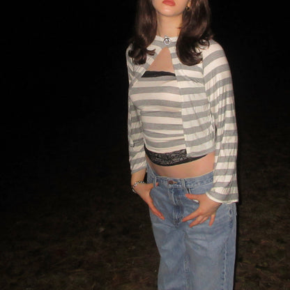 Person wearing a striped shirt and jeans against a dark background