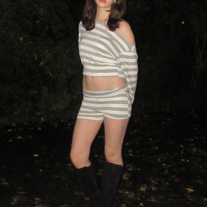 Person wearing a striped outfit standing in a dark outdoor setting